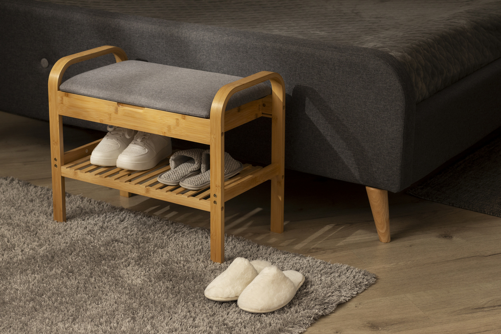 Zapatero tipo banco en el dormitorio que ofrece almacenamiento funcional y un cómodo asiento acolchado. Perfecto para mantener el calzado ordenado sin perder estilo y comodidad en el ambiente más personal del hogar.